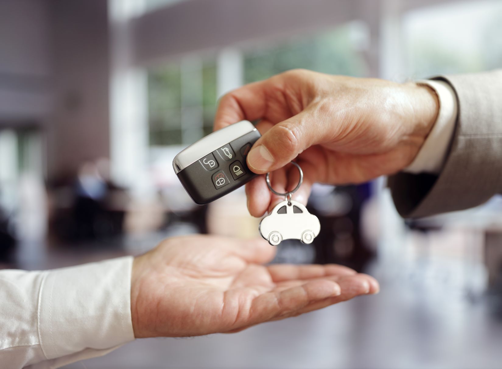 car salesman handing car keys