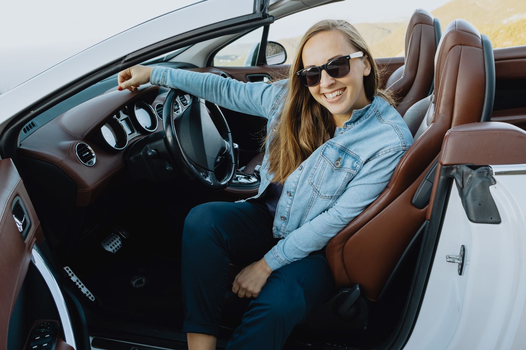 woman smiling in her convertible sports car