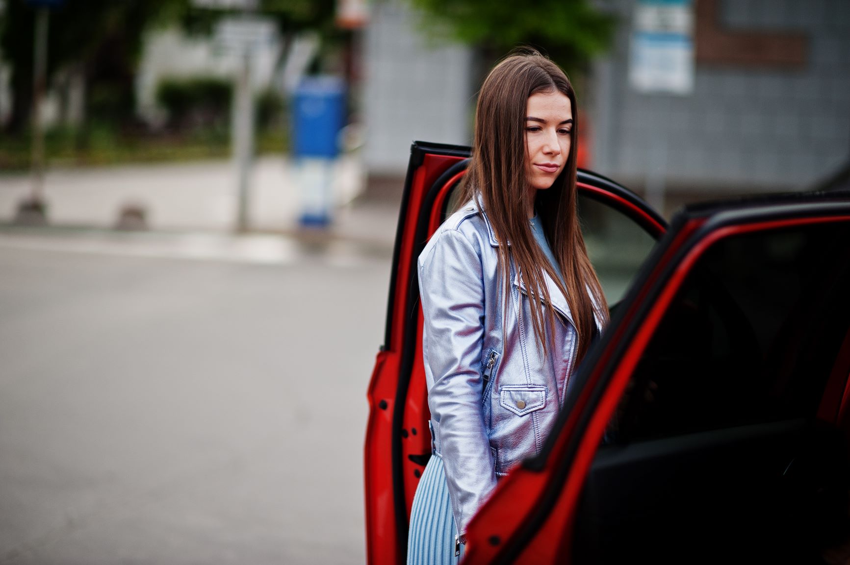 woman standing next to red car
