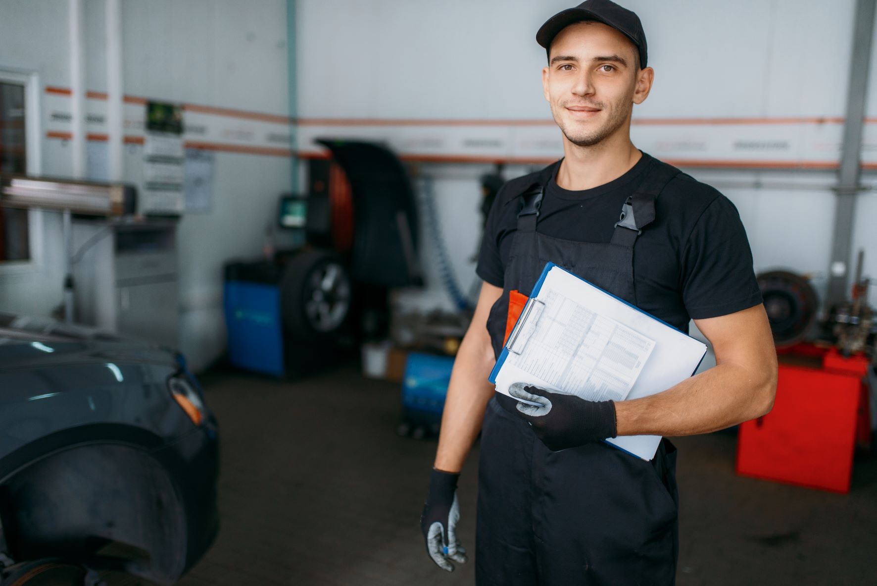 car mechanic in front of car with report