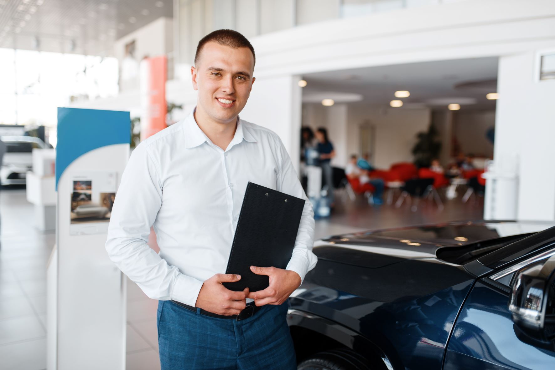 car salesman standing in car dealership