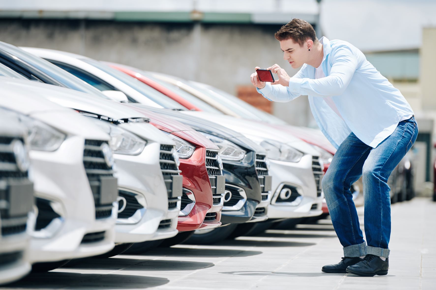 customer at car dealership taking pictures