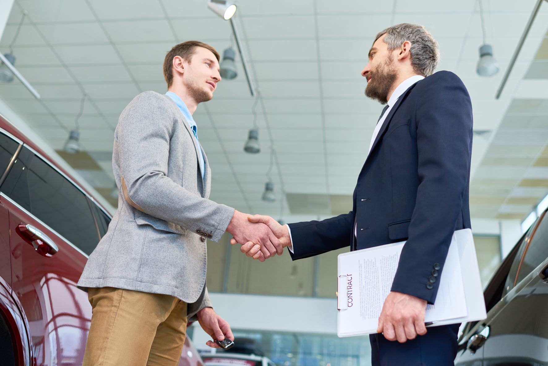 car salesman shaking customers hand