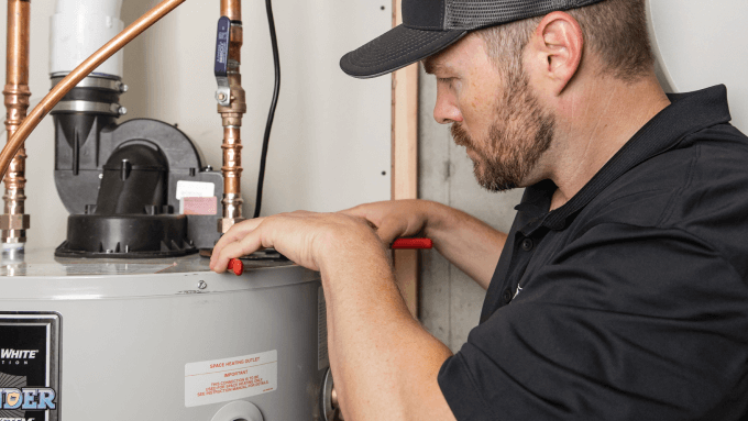 A technician installing a power vent water heater.