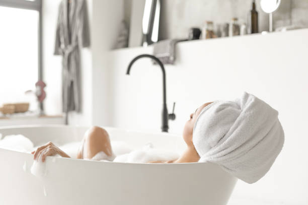 Young attractive woman relaxing in bathtub bath stock pictures, royalty-free photos & images