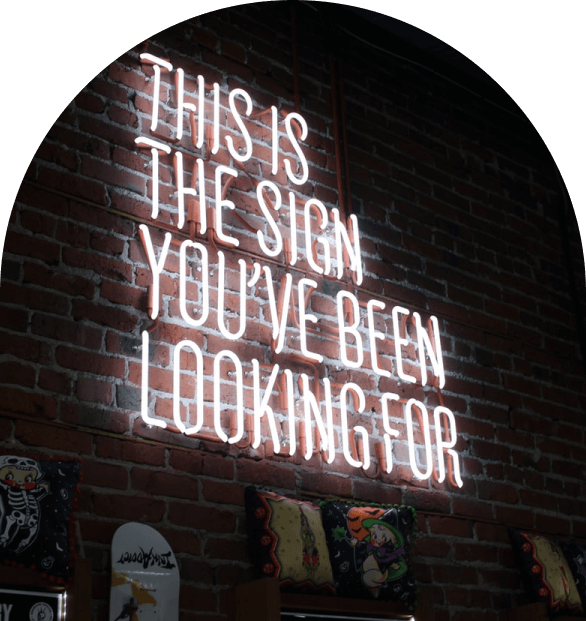 Neon sign that says "This is the sign you've been looing for" with a dark background.