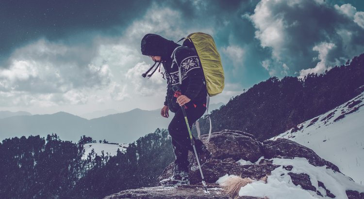 Man standing on top of a mountain covered in snow.