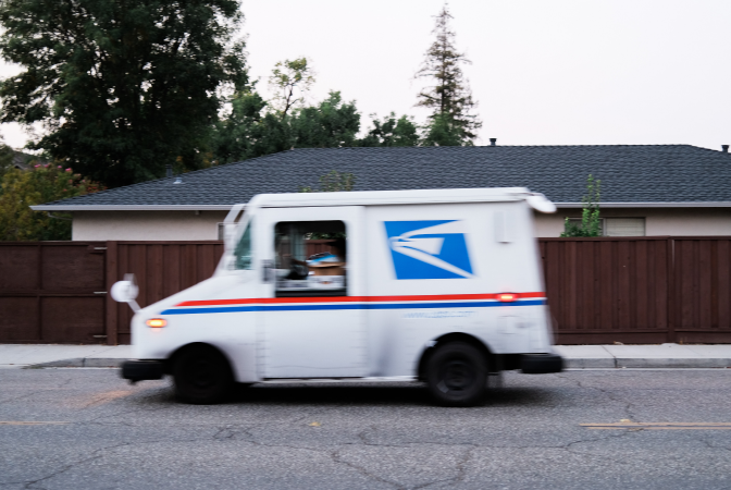 A USPS (United States Postal Service) truck delivering packages from online purchases
