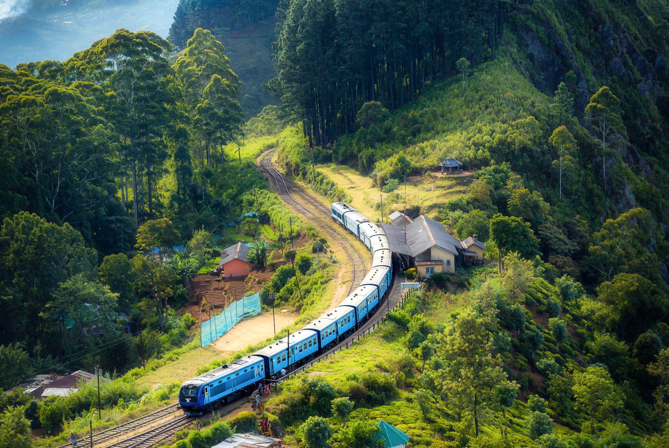 Locomotive parked at train station ina lush valley