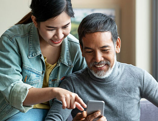 A father and his daughter looking at a cell phone