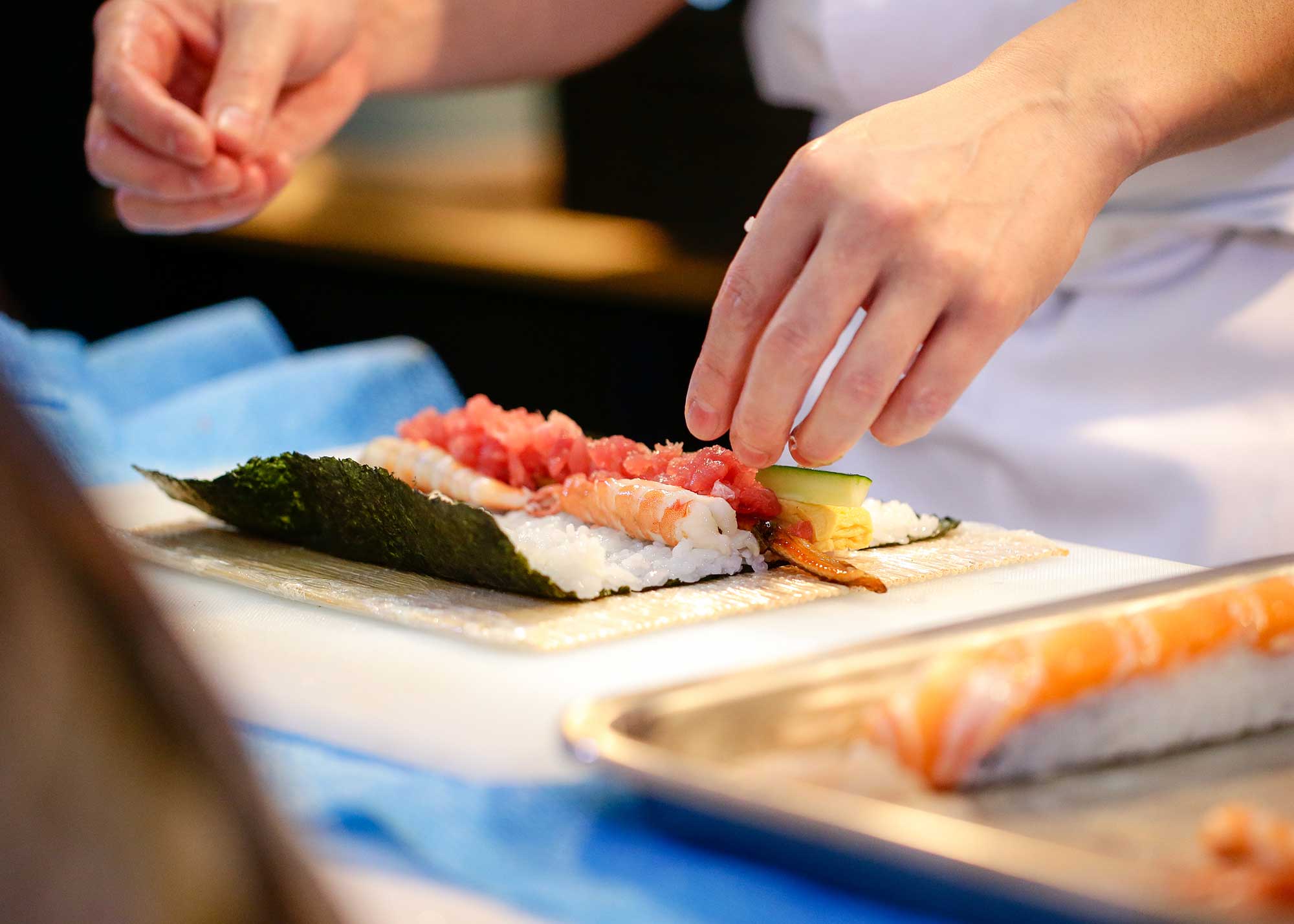 A person rolling a sushi roll