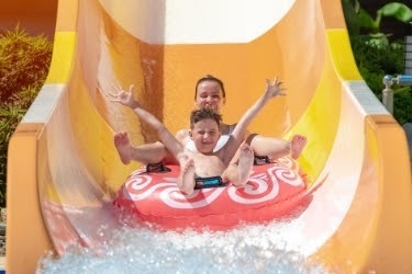 Woman and kid playing in the water slide.