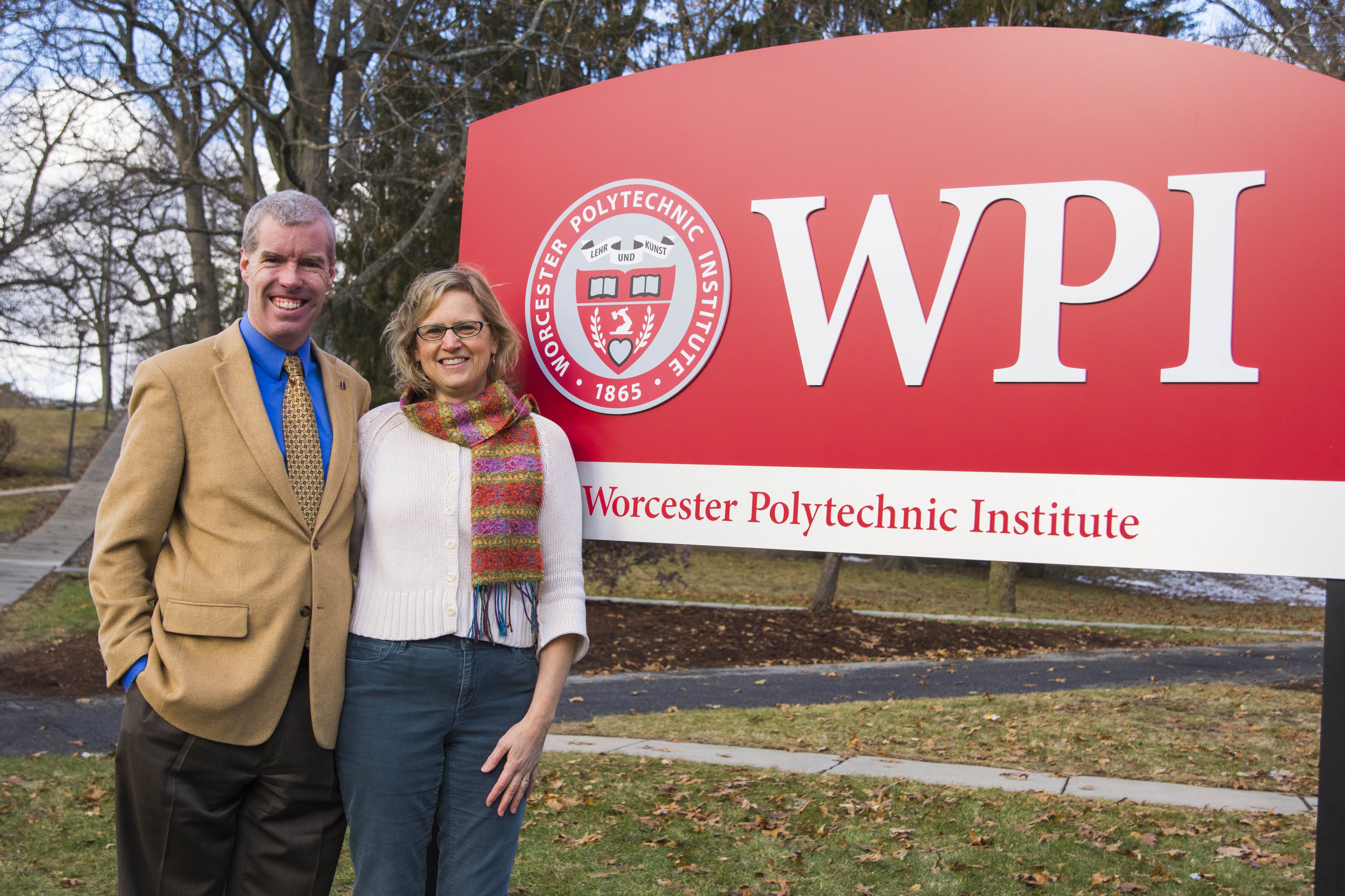Two People Standing Next to WPI Sign