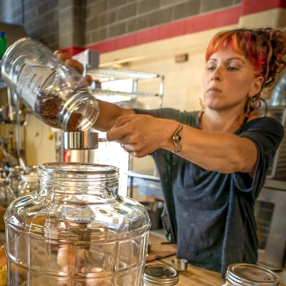Annie pouring ingredients while making a batch of fire tonic