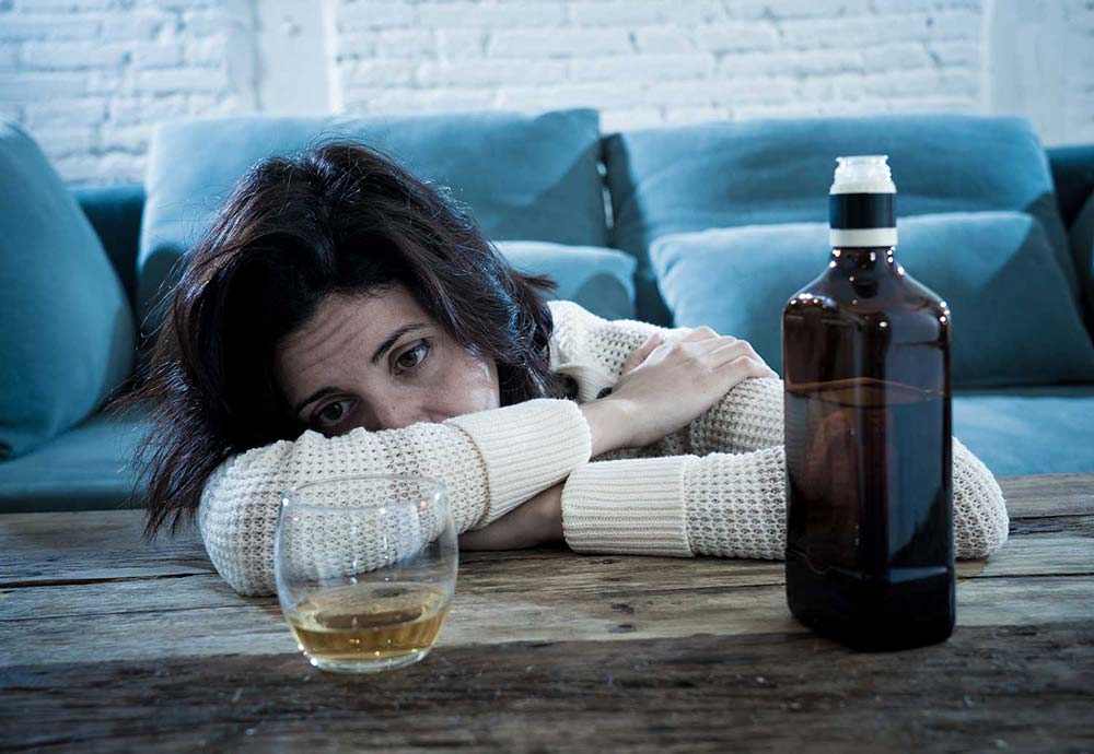 A lady drinking at a table, Alcohol Monitoring, The Barrows Firm