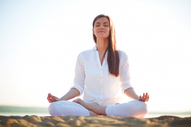 woman-doing-yoga-exercises-on-the-beach_1098-1449