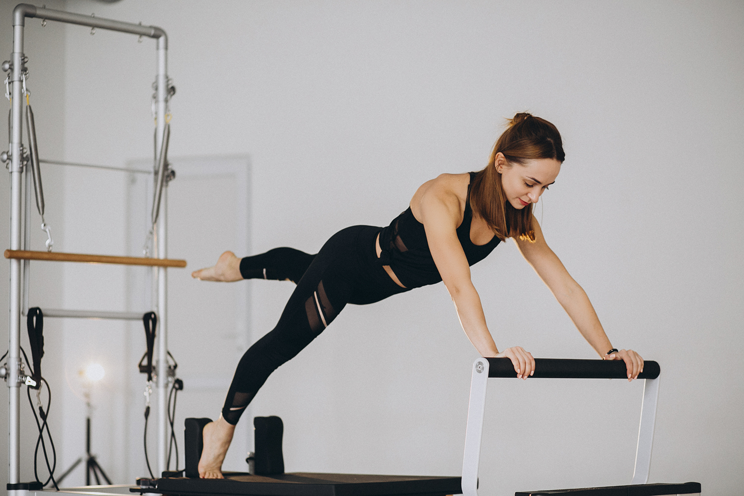 Woman doing pilates on a reformer|pilates|pilates-resources