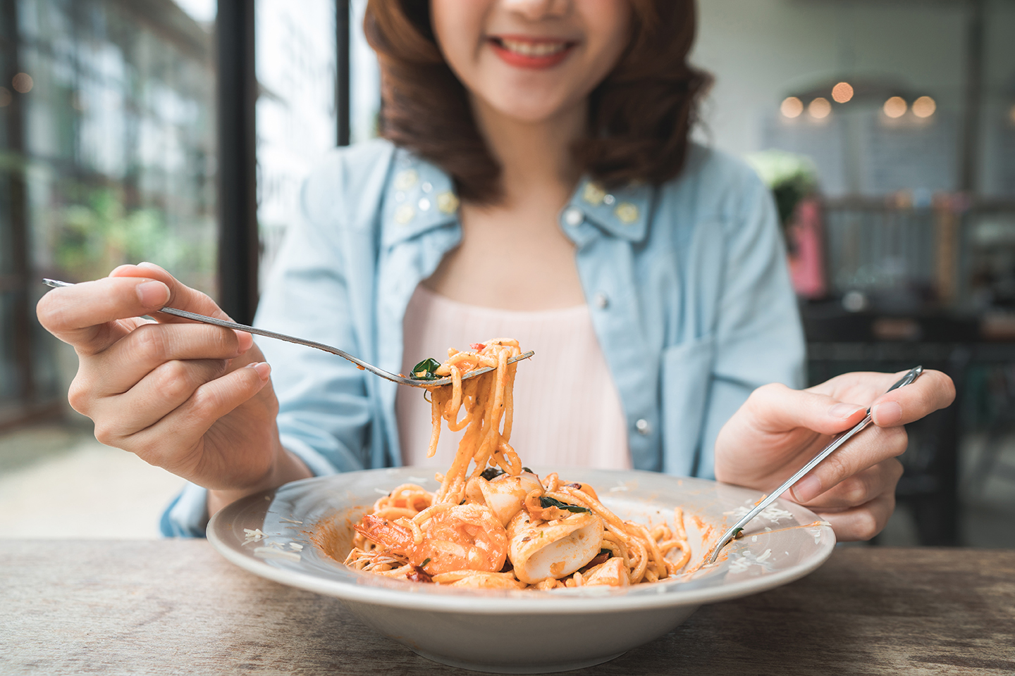 mindful eating|mindful-eating|Woman's hands with Caesar salad on table in restaurant|mindful-eating