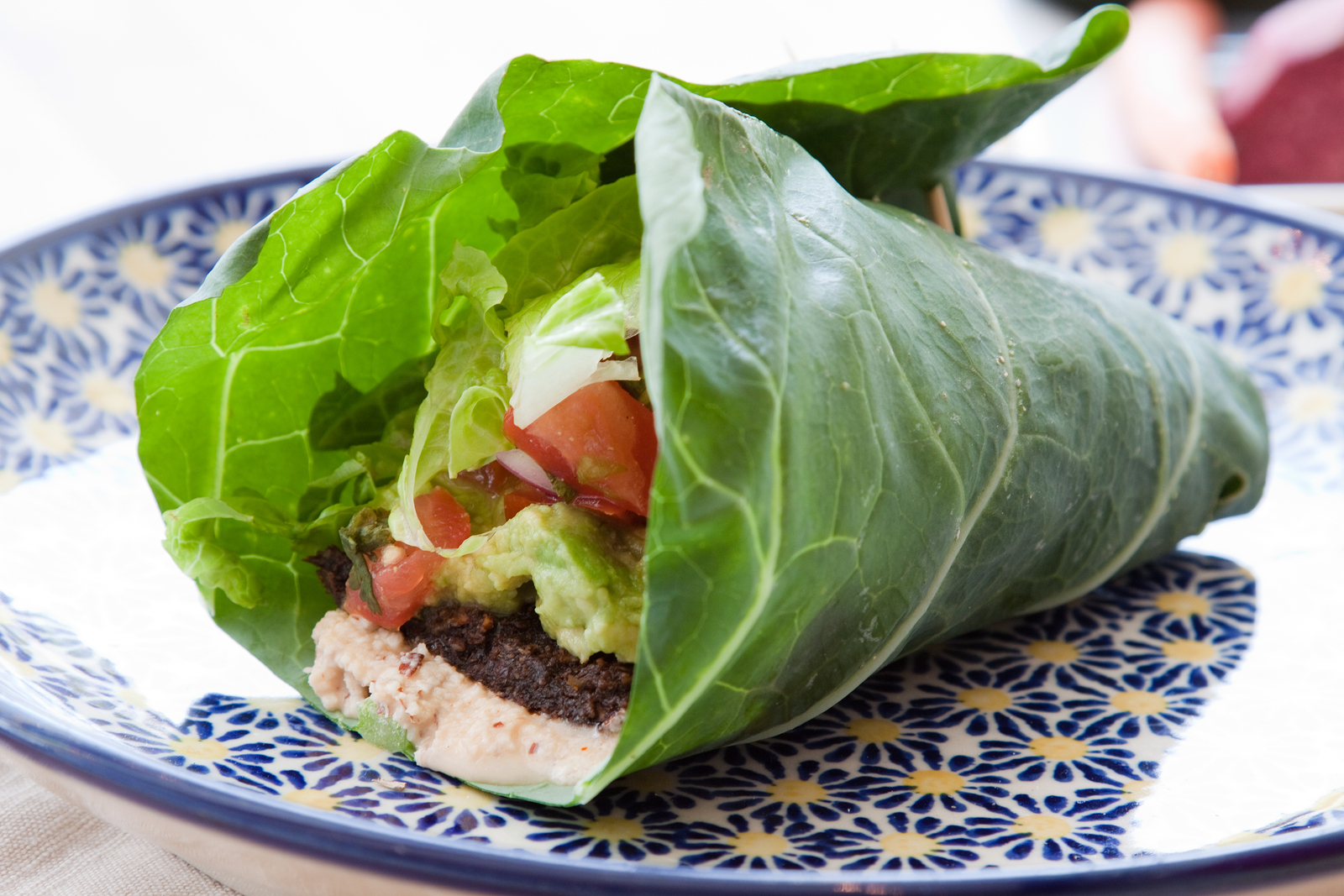 Seasoned nut loaf guacamole romaine lettuce salsa & almond nut cheese wrapped in a collard leaf.