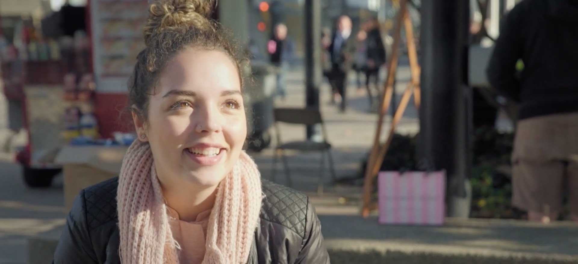 girl smiling at camera in scarf in city