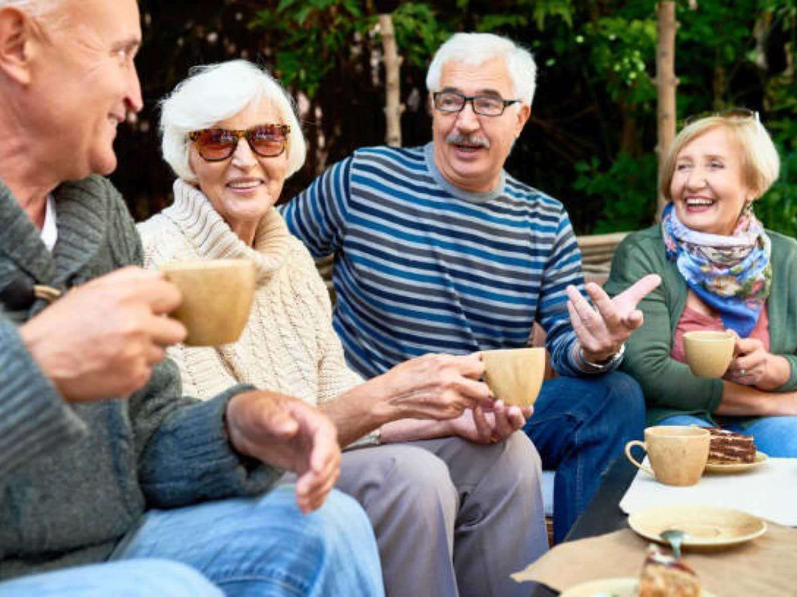 Older people enjoying a chat and coffee outside