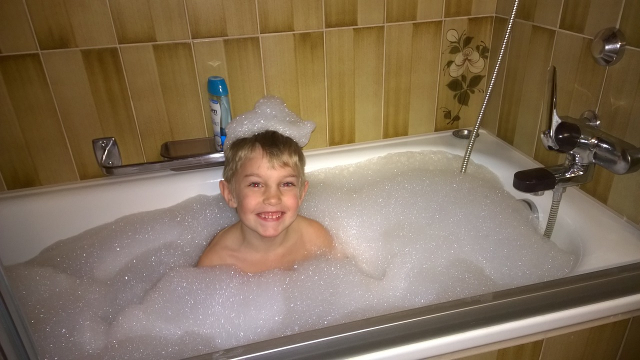 boy in bathtub full of bubbles.