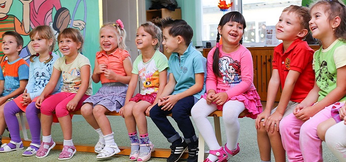 children in classroom sitting on a bench