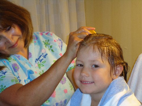 LiceDoctors professional technician treating smiling child