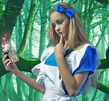 photo of blonde girl dressed like Alice in blue dress with white apron holding DRINK ME potion.