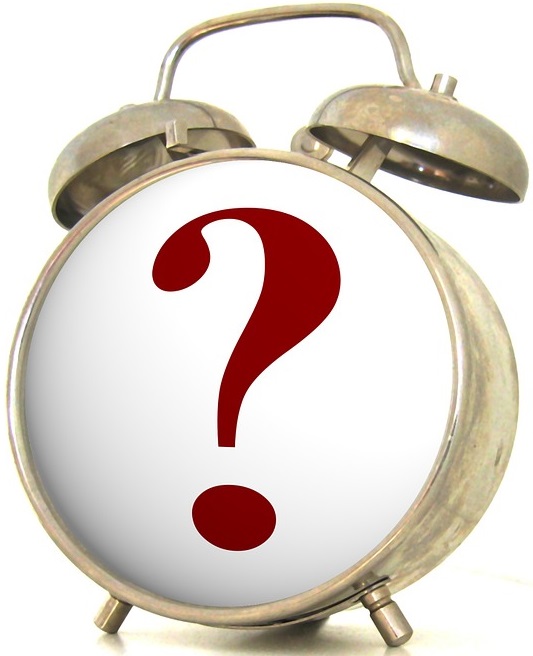 old fashioned brass alarm clock with question mark on face.