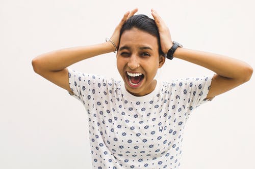 anxiety woman screaming holding her head.