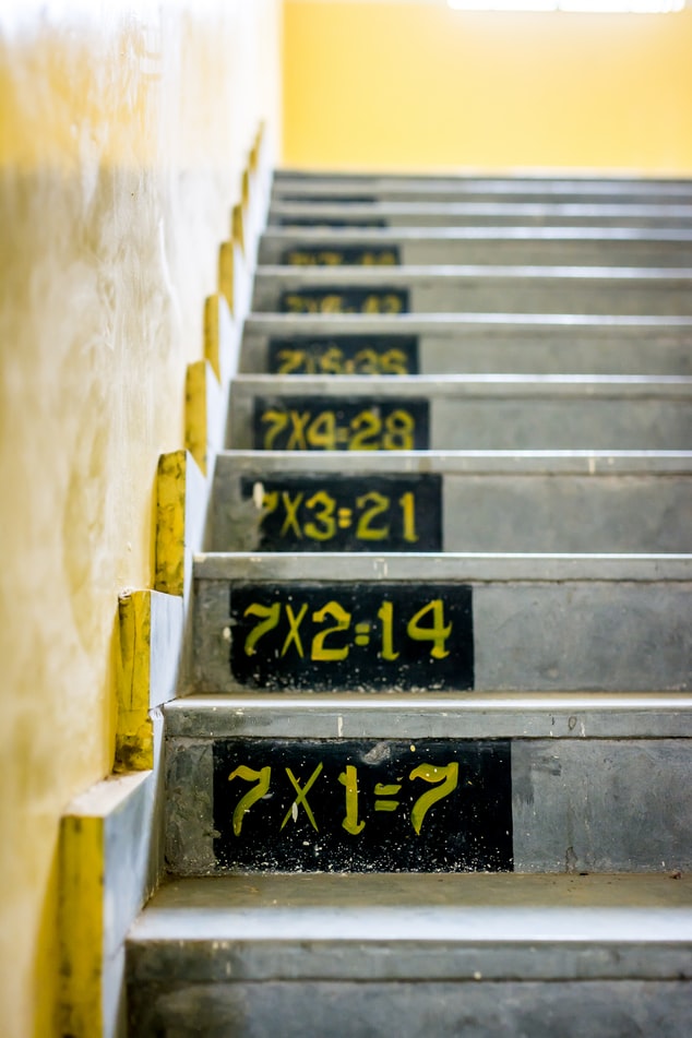 cement steps painted with multiplication tables for multiples of seven 7X1=7, 7X2=14, etc.