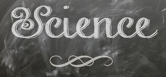 cursive white chalk letters on a blackboard chalkboard reading SCIENCE