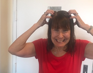 grimacing woman with brown hair scratching at her head evoking crazy anguish