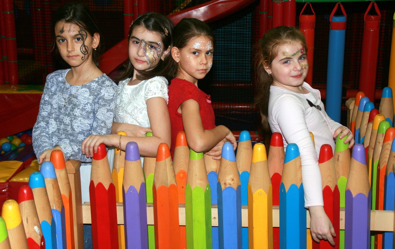 kids leaning on colored pencil fence