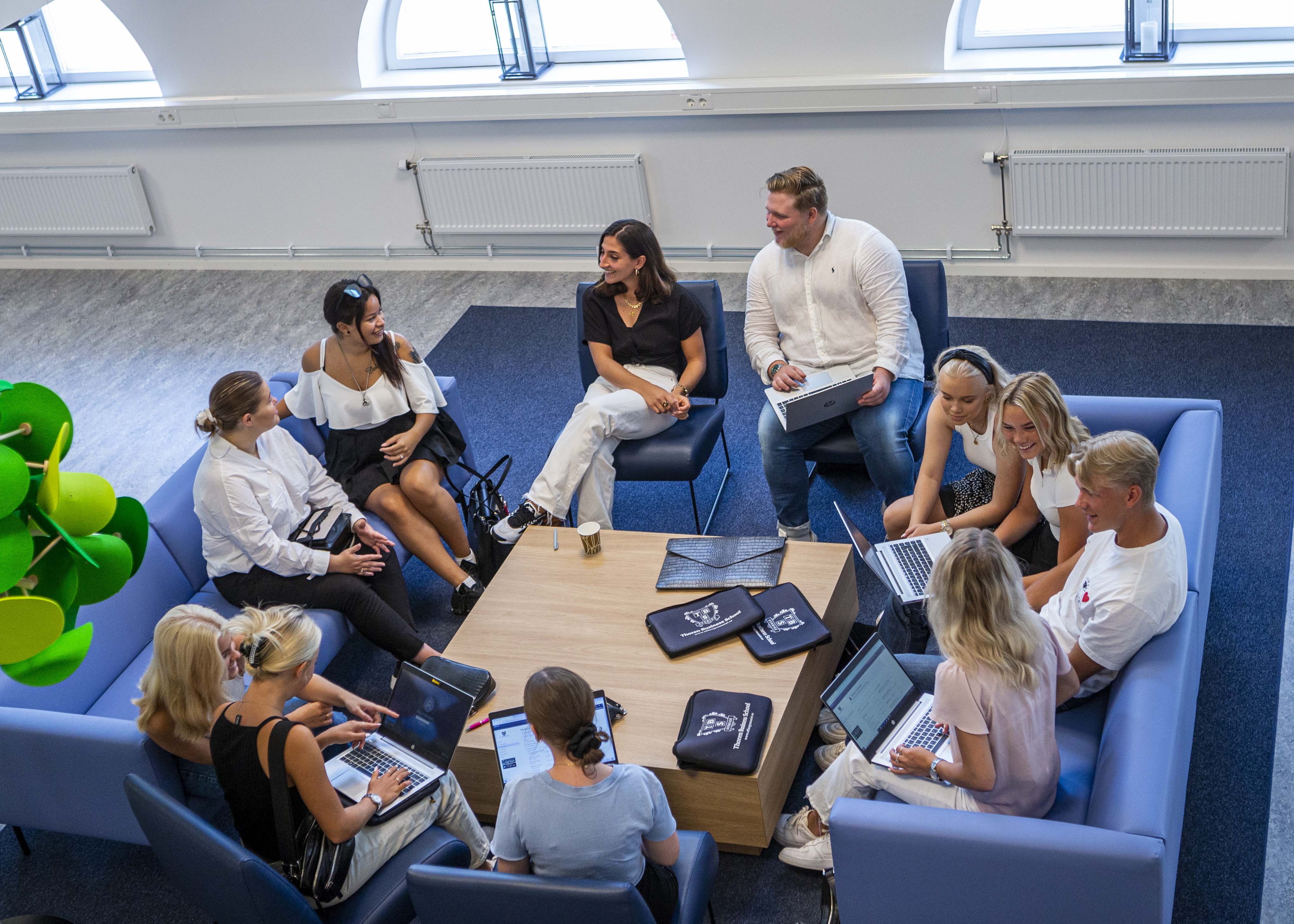 Elever sitter vid soffgrupp och pratar