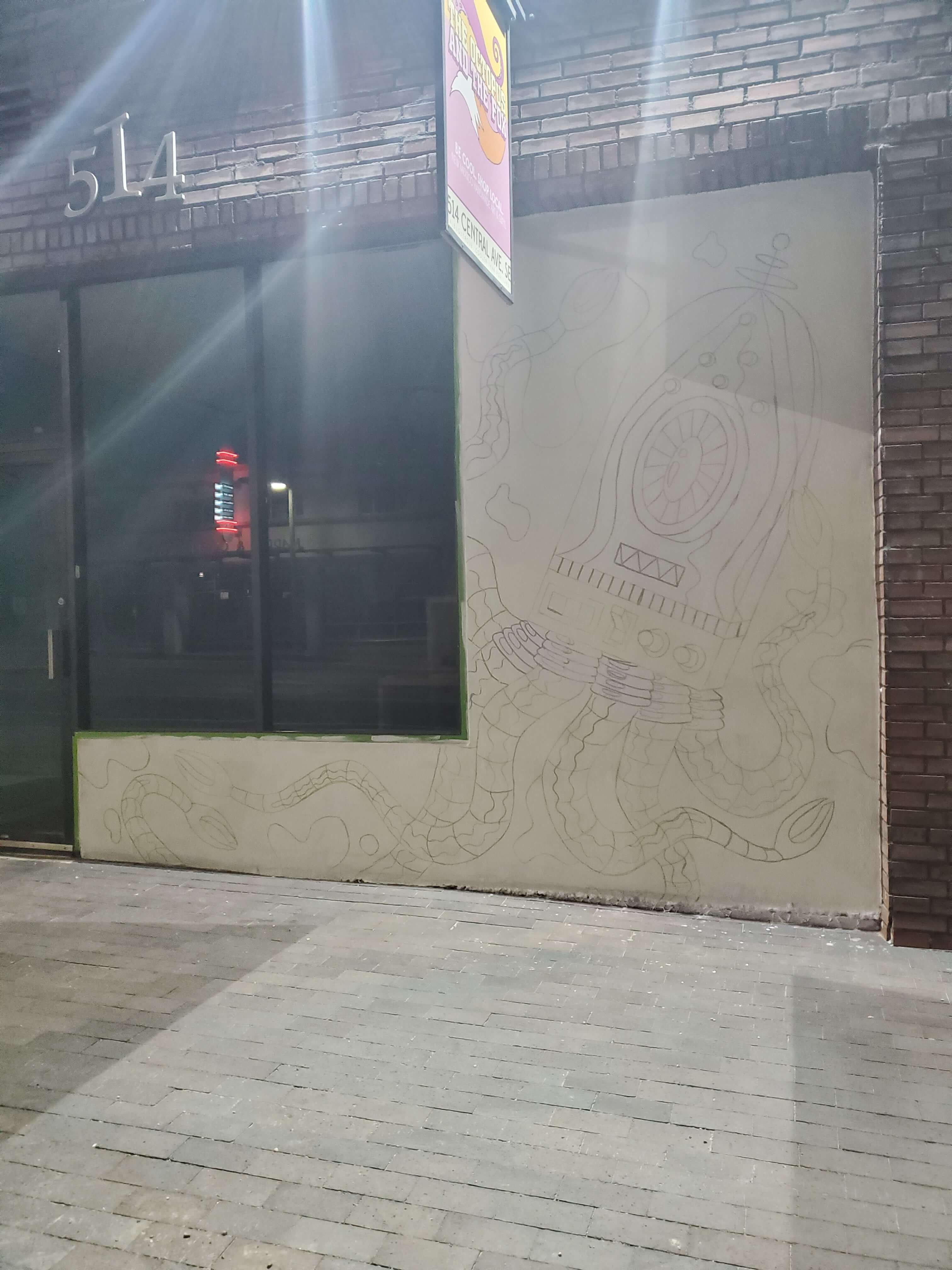 A photo of the outline process for the Squidly Storefront Mural