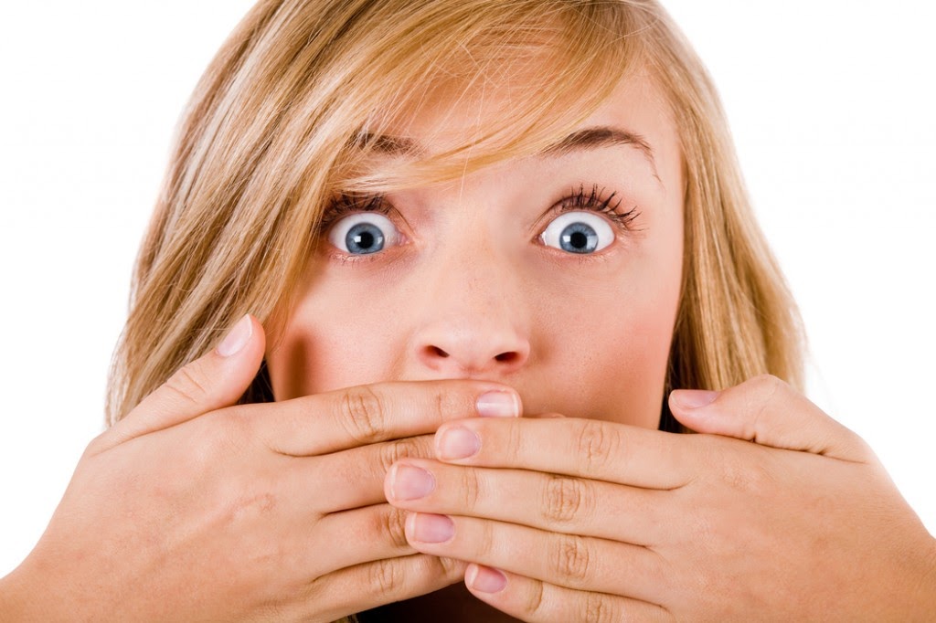 Closeup of young women covering her mouth with both hands