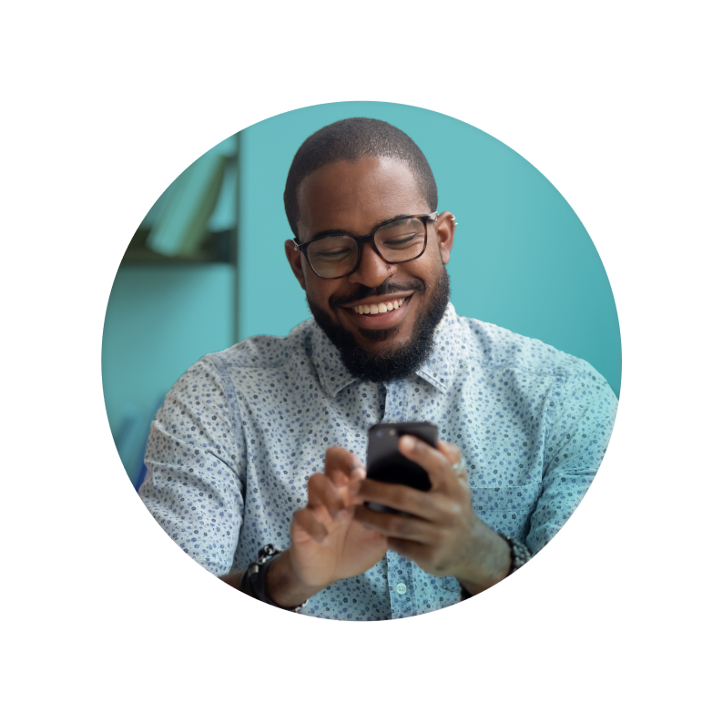 Man smiling while texting, on turquoise background