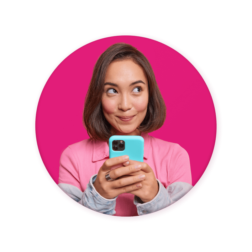 Woman smiling while holding phone, on pink background