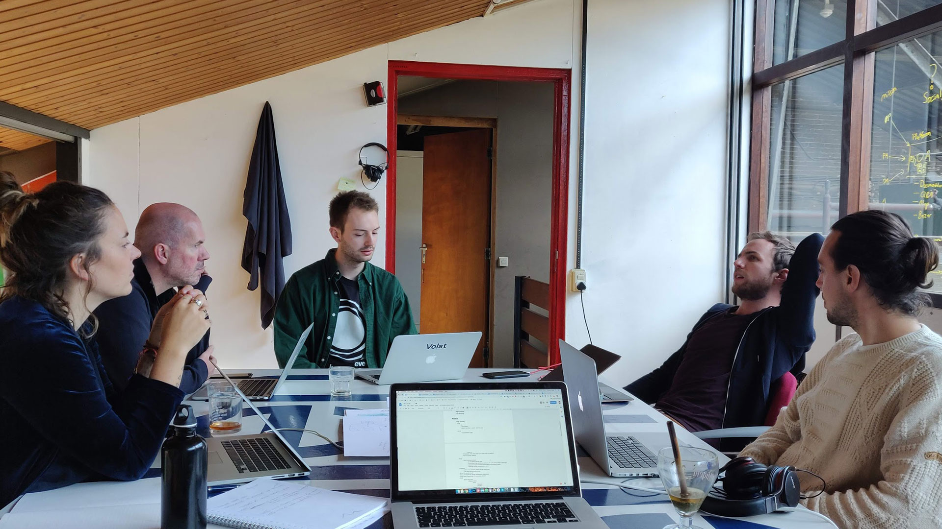5 PEOPLE AROUND A TABLE having a meeting