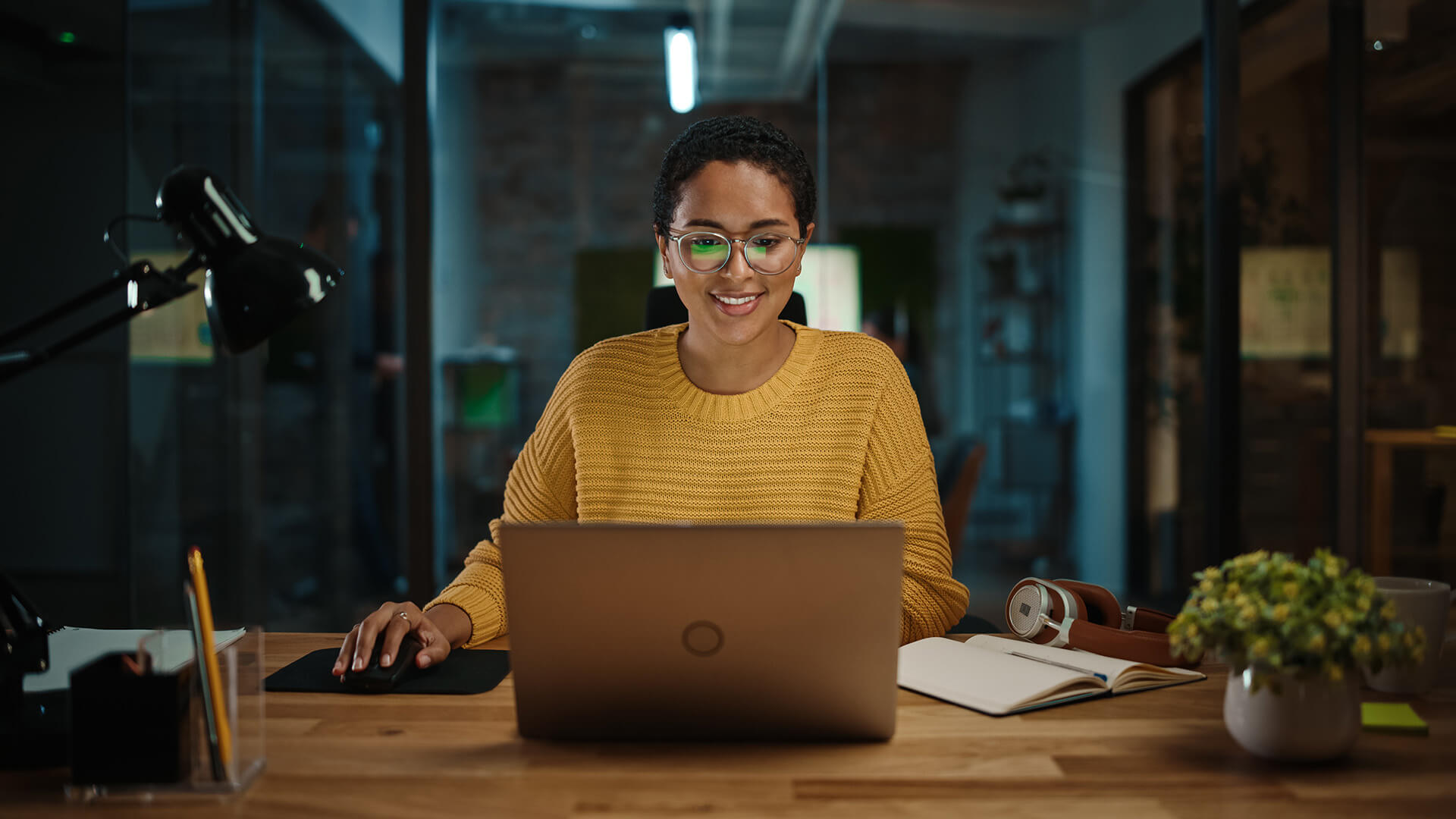 Young Woman in a Agency with Laptop. Evening.