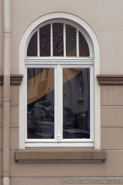 Altes Rundbogenfenster mit verschiedenen Glasarten