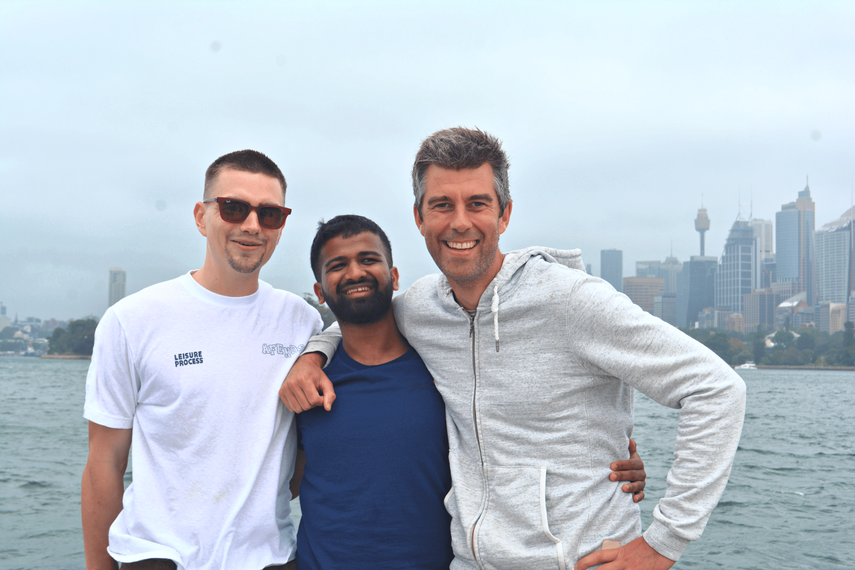 Three men posing and smiling on a boat