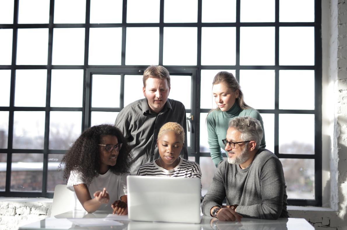 Five publishers looking at a computer.