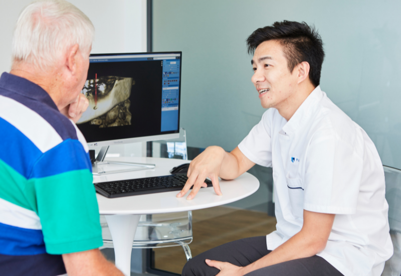 A dentist discusses dry socket with his tooth extraction patient