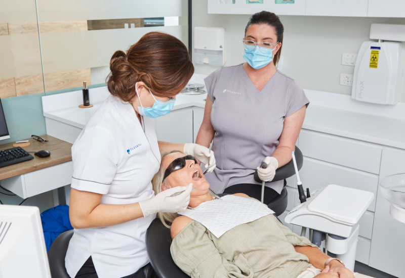 A dentist at TL Dental examines their patient to determine which type of tooth filling is required