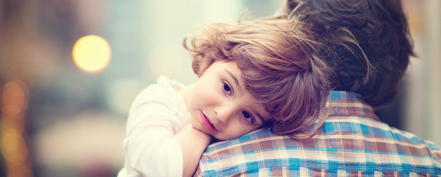 Little girl resting her head on her father's shoulder