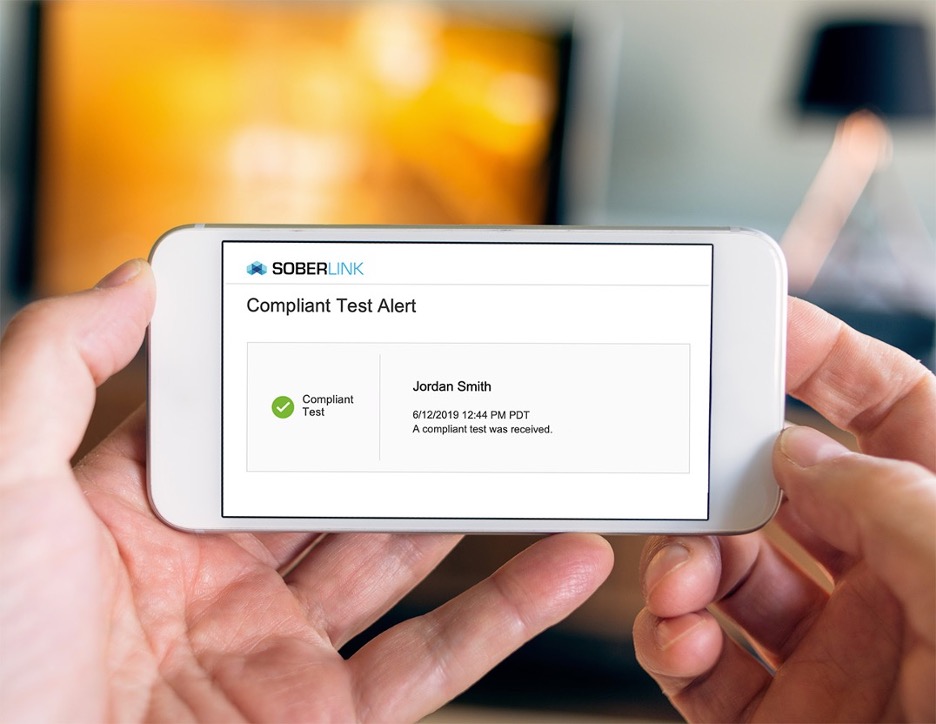 Person Holding an iPhone with a Soberlink Notification