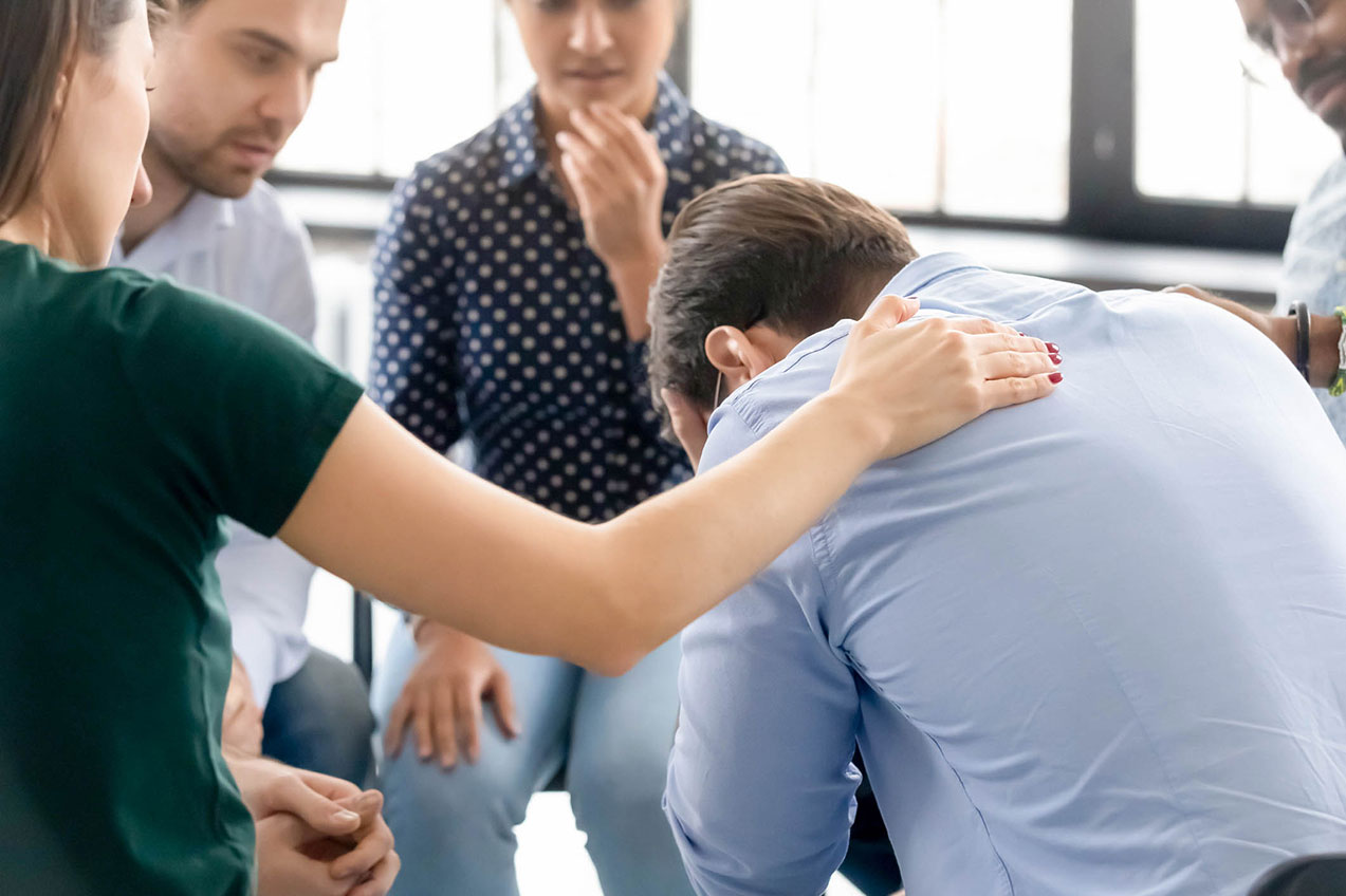 A woman comforts a man who had challenges with a loved one's recovery